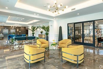Lobby with two yellow chairs are beside the leasing office and elevators at Hollywood Heights on the Boulevard Luxury Apartments in Hollywood, FL